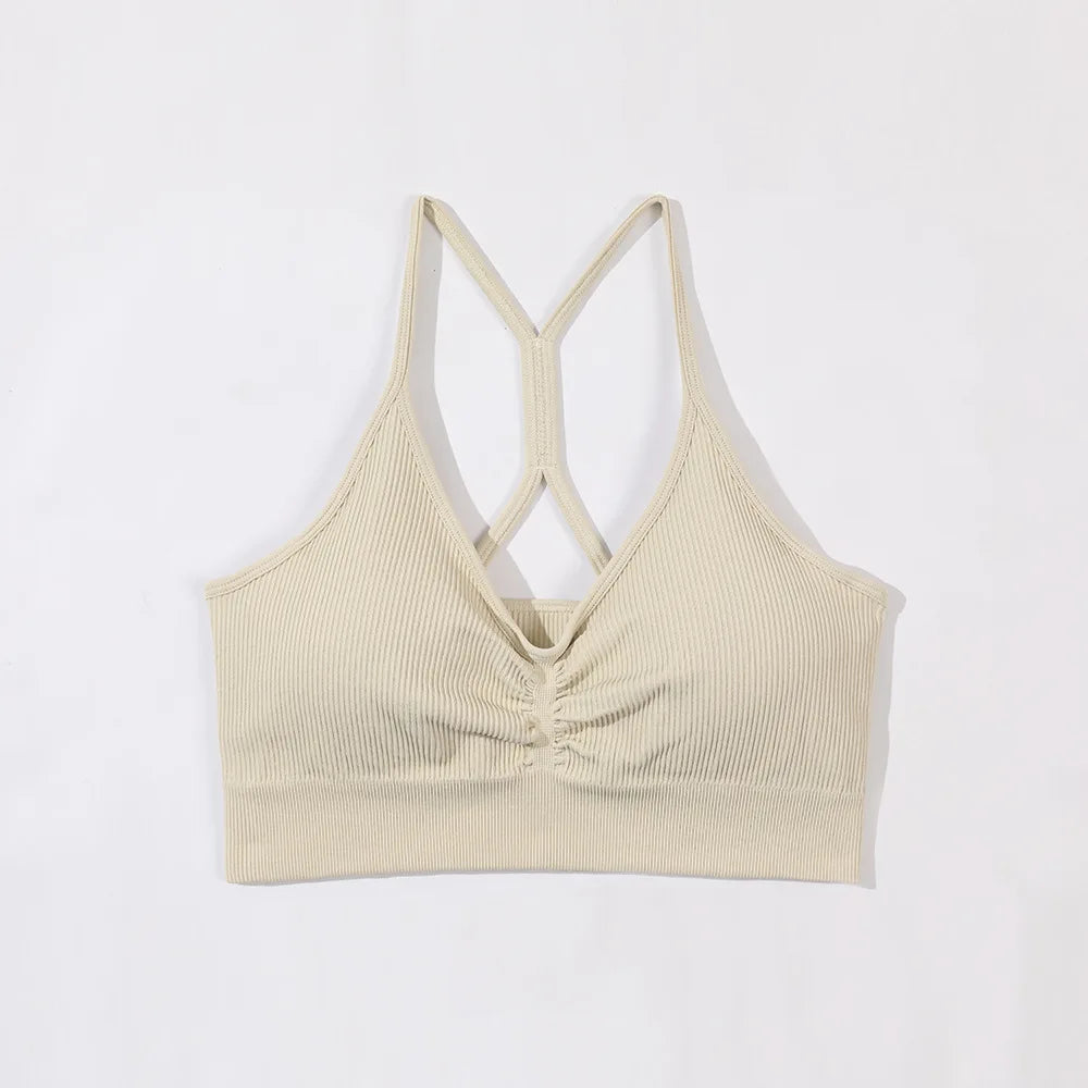 Beige ribbed tank top with criss-cross straps on a white background