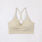 Beige ribbed tank top with criss-cross straps on a white background