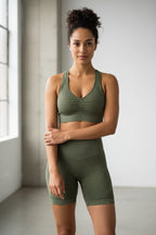 Green ribbed knit clothing set including a cardigan, leggings, and two tops on a white background