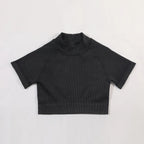 Black ribbed knit crop top on a light gray background