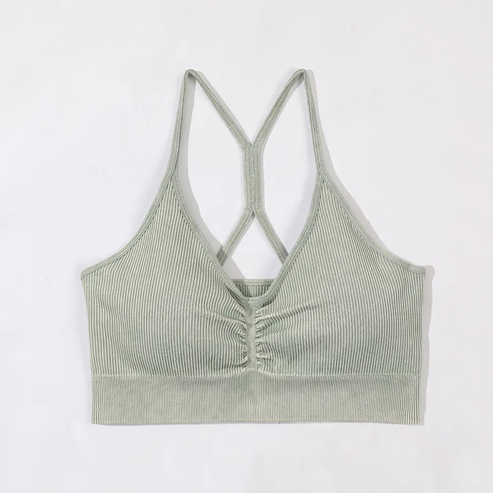 Green ribbed tank top with criss-cross straps on a white background
