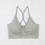 Green ribbed tank top with criss-cross straps on a white background
