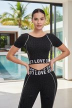 Woman wearing a black athletic outfit with 'LOVE' branding on a white background
