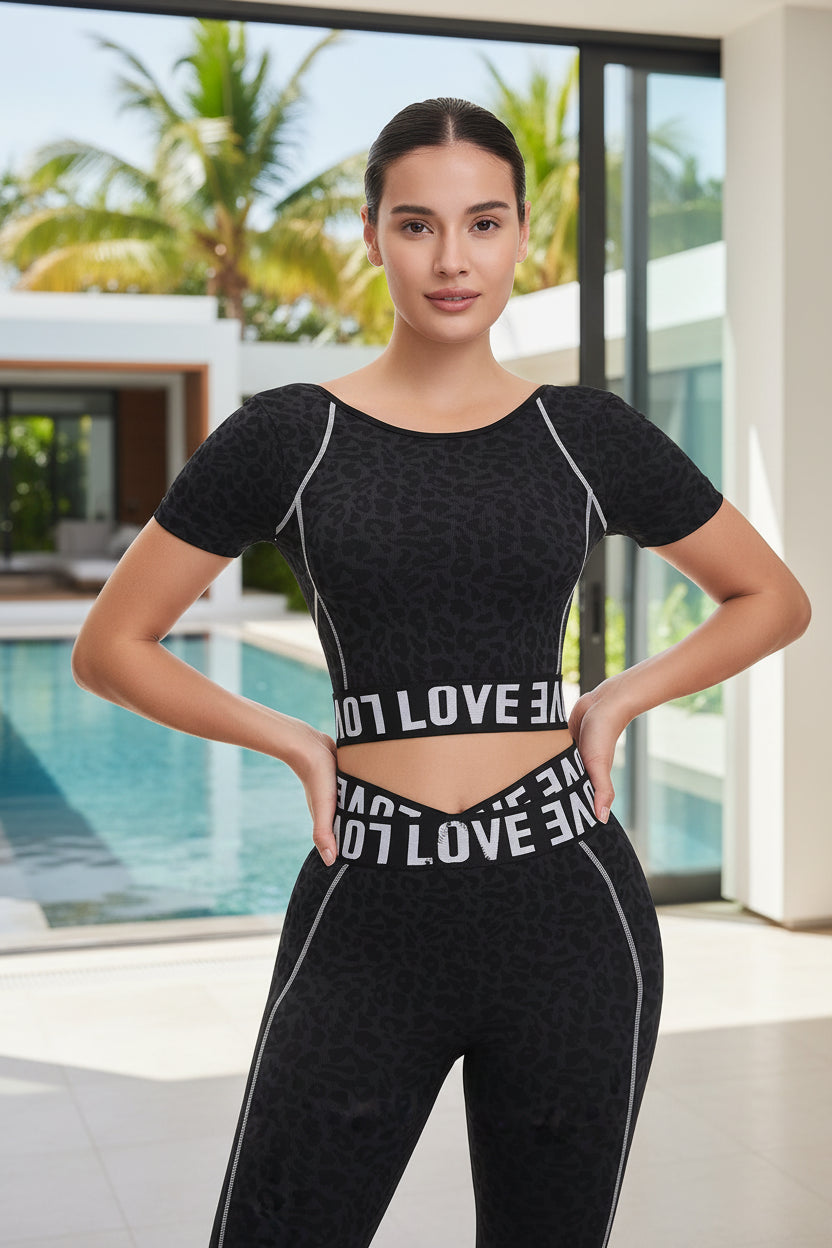 Woman wearing a black athletic outfit with 'LOVE' branding on a white background