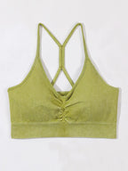 Green ribbed crop top with criss-cross straps on a white background