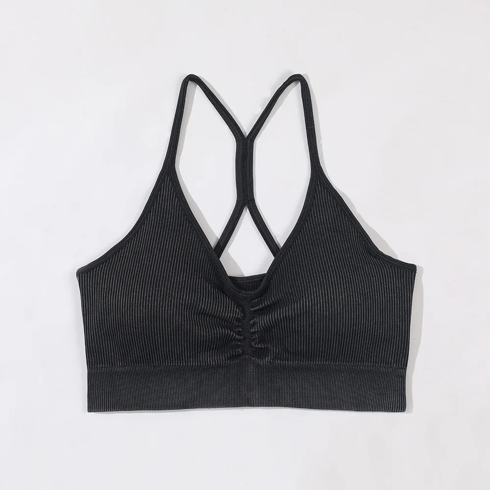 Black ribbed sports bra with criss-cross straps on a light gray background
