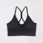 Black ribbed sports bra with criss-cross straps on a light gray background